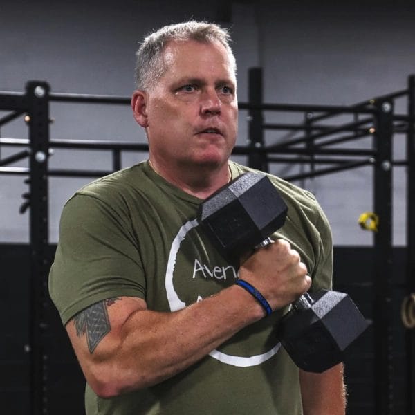 Man with dumbells at Avenger Athletics
